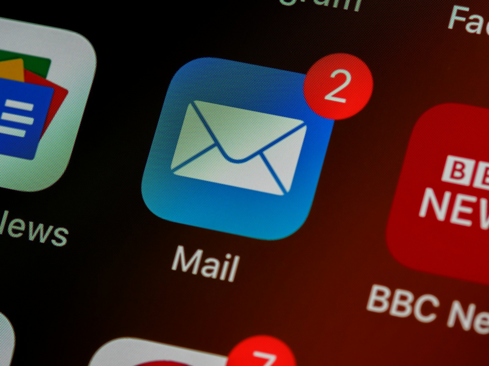A close-up of a mail app icon on a phone, representing email marketing campaigns